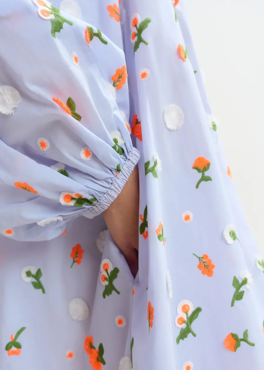 Light blue knee-length dress with mandarin collar and green and orange embellishments