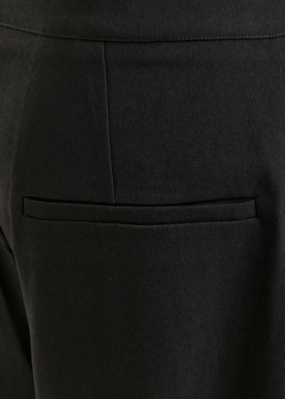 Zwarte broek met barrelpijp en gebogen zijnaad