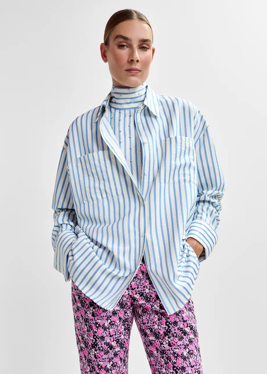 Light blue and off-white oversized shirt with rhinestone embellishments and layered bib