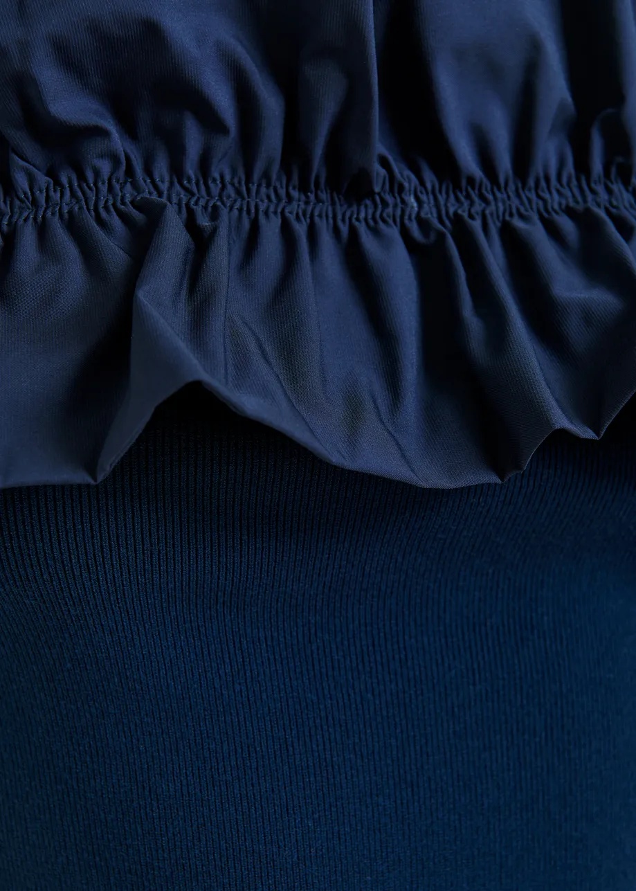 Donkerblauwe gebreide top met blote schouders en volant