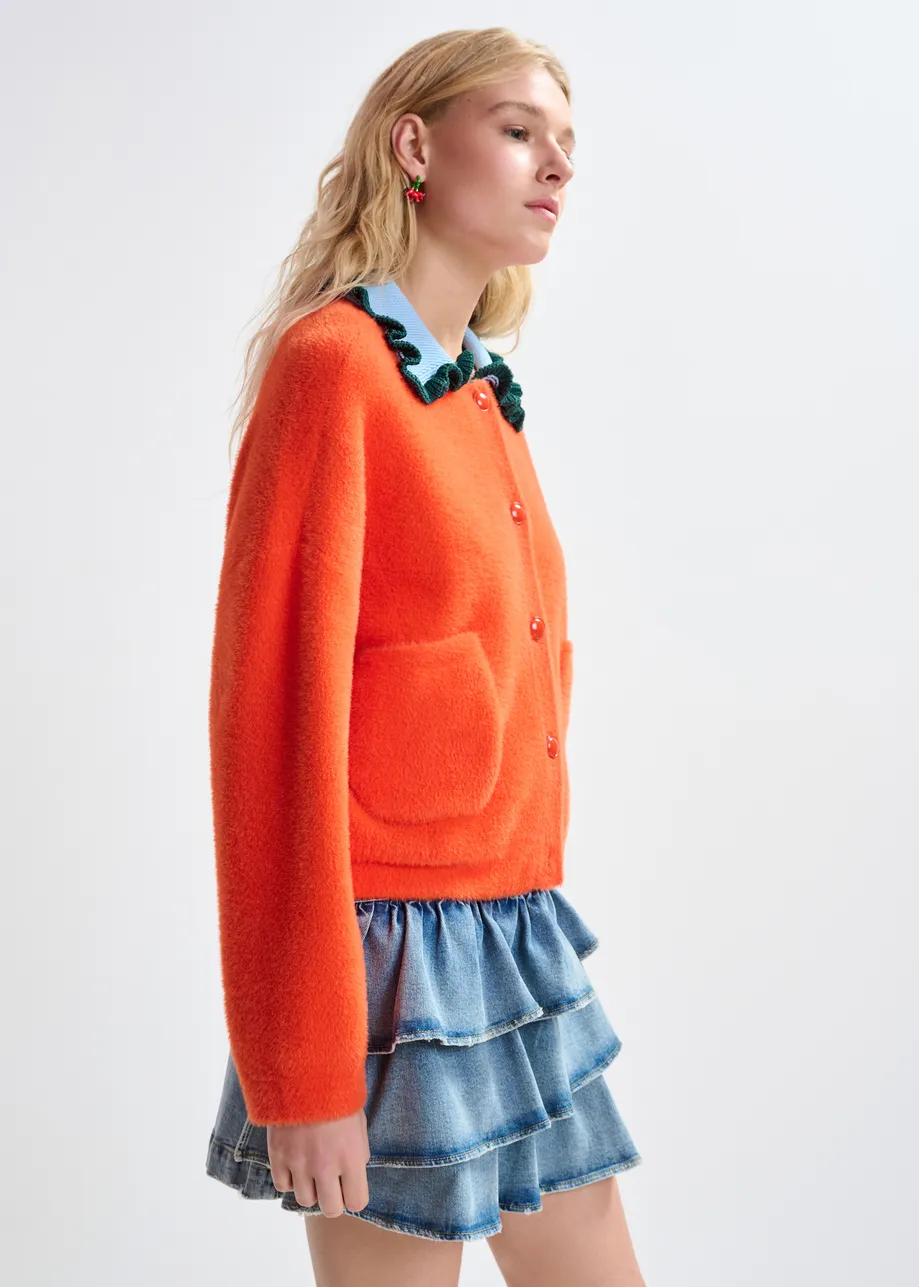 Orange cardigan with contrasting light blue and dark green ruffle collar