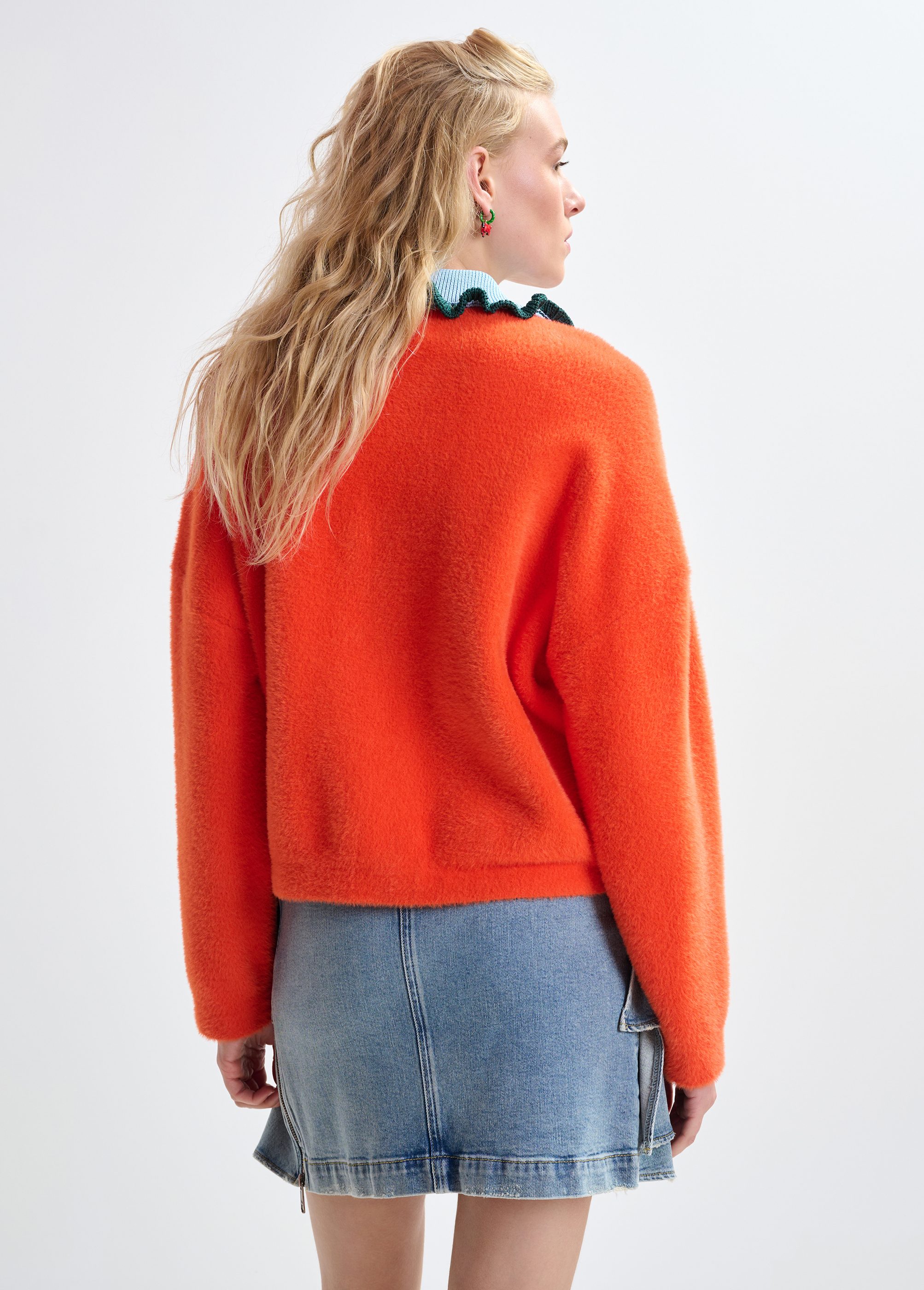 Orange cardigan with contrasting light blue and dark green ruffle