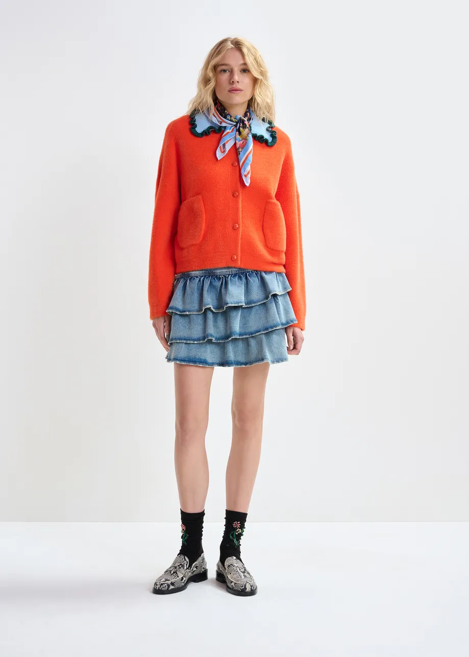 Orange cardigan with contrasting light blue and dark green ruffle collar
