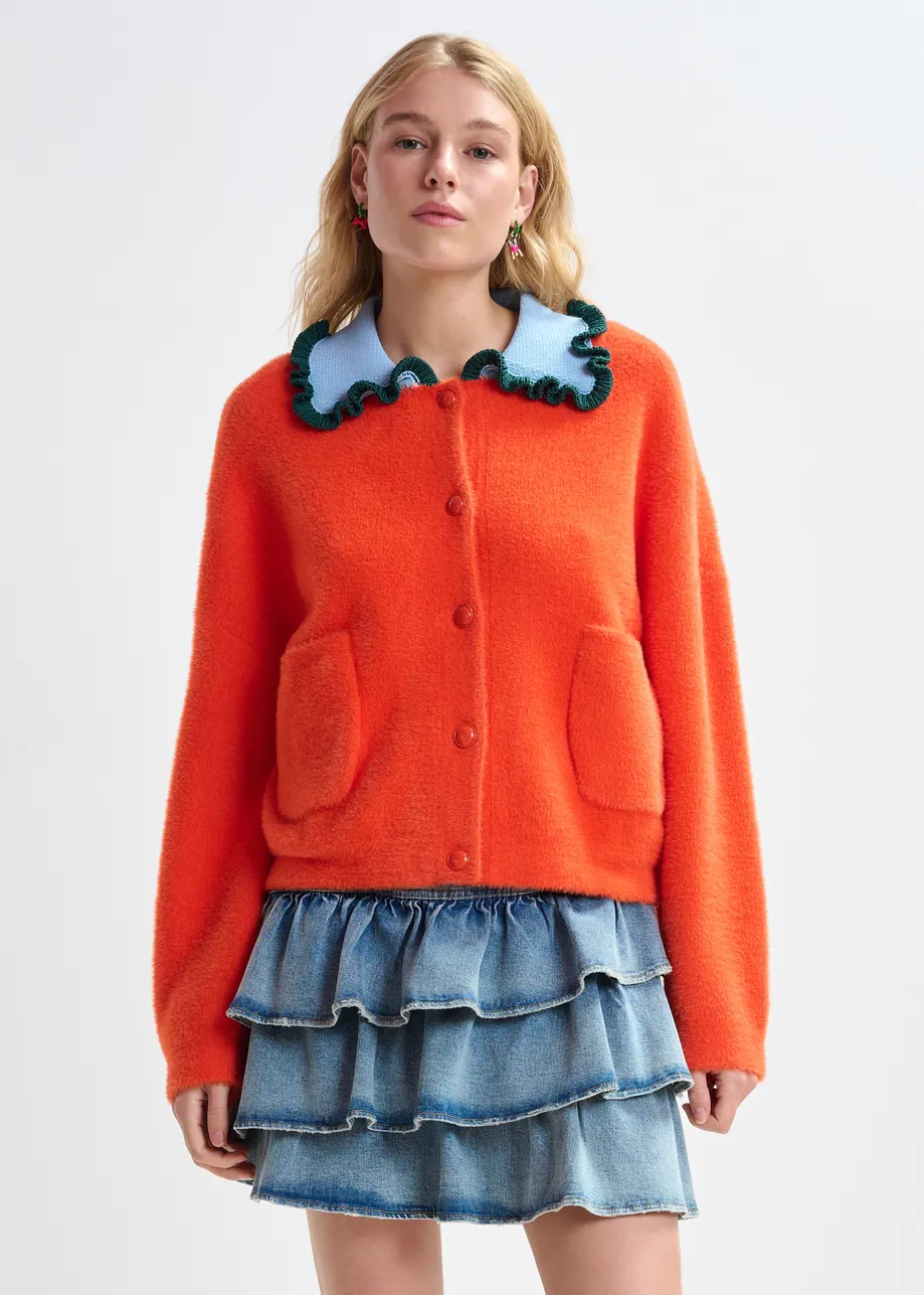 Orange cardigan with contrasting light blue and dark green ruffle collar