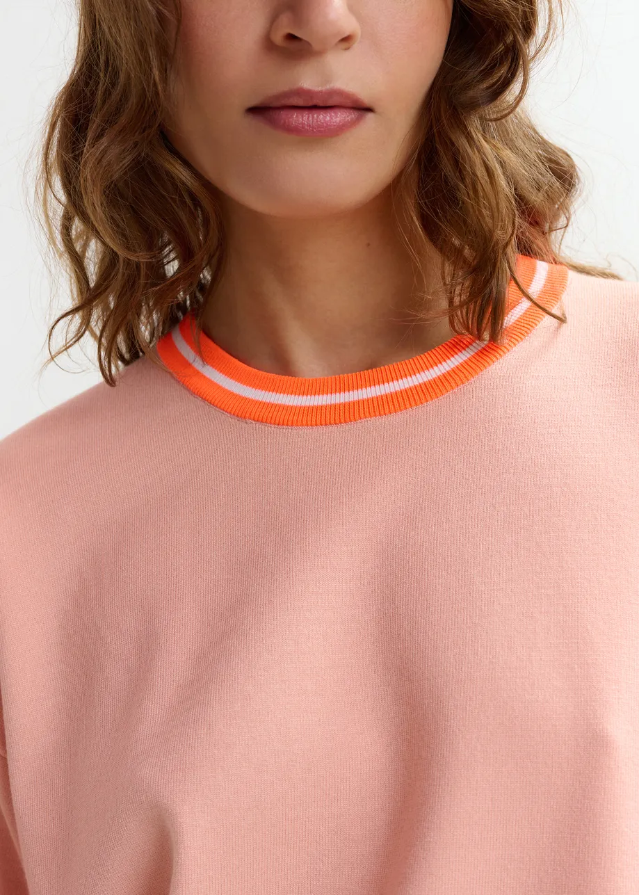 Korter lichtroze gebreid T-shirt met oranje contrastboord