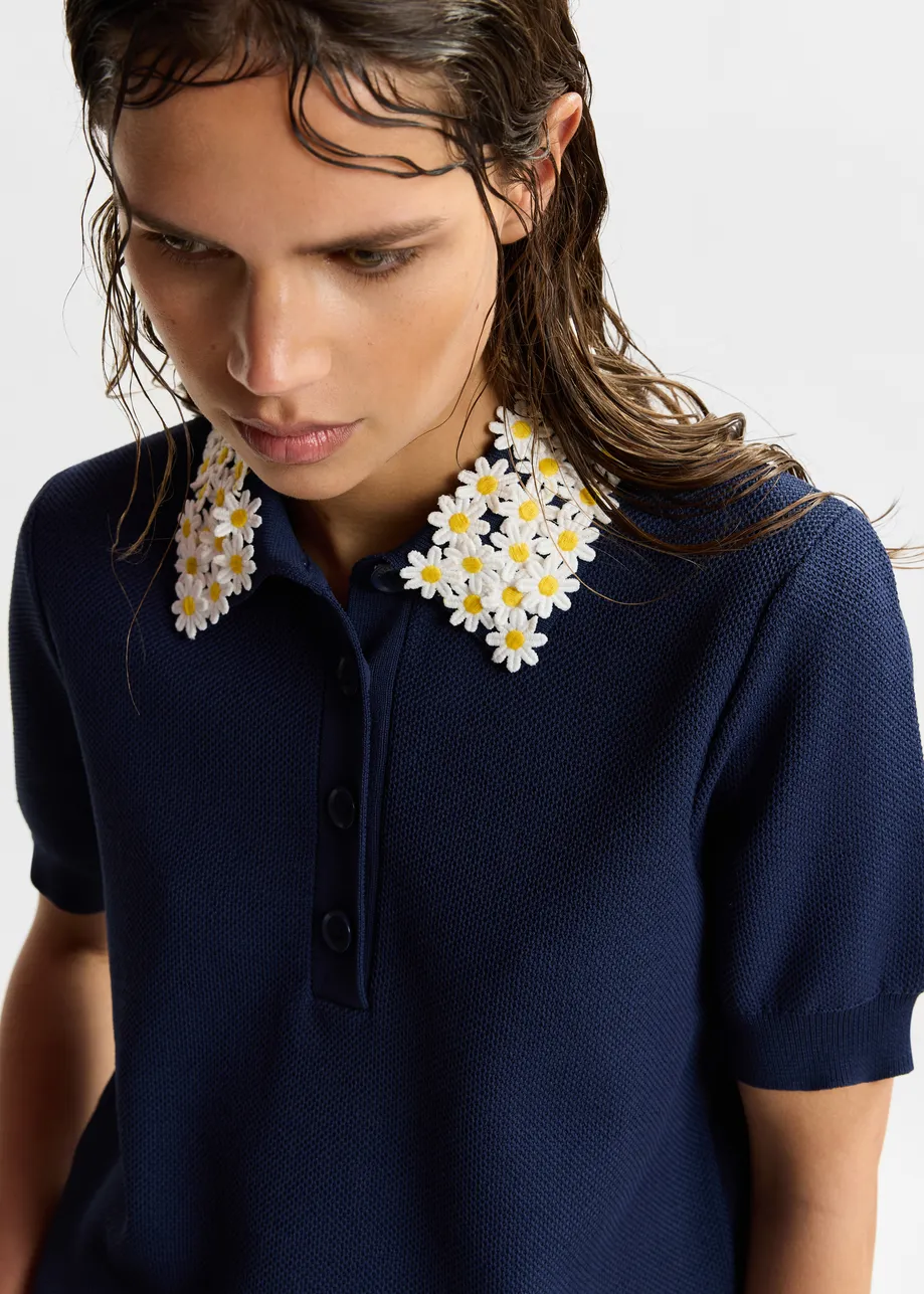 Dark blue fine knit polo top with white and yellow floral embellished collar
