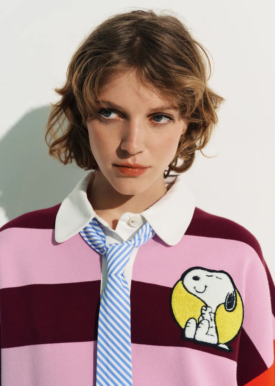 Pink and burgundy striped polo sweater with Peanuts™ patch and text