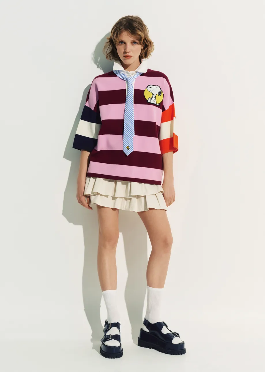 Pink and burgundy striped polo sweater with Peanuts™ patch and text