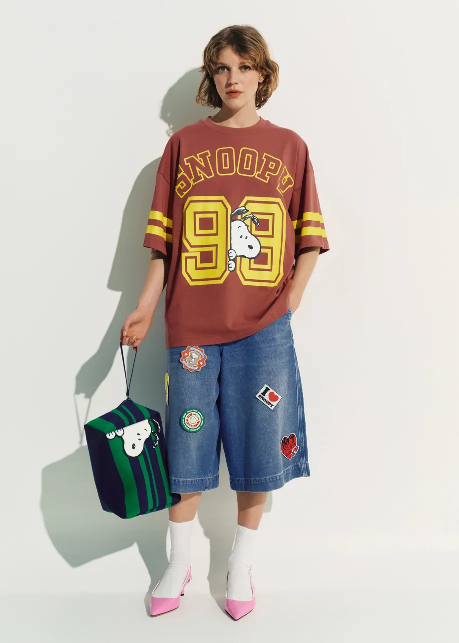 Pochette à rayures marine et verte avec motif Peanuts™ Snoopy et broderie de texte lilas.