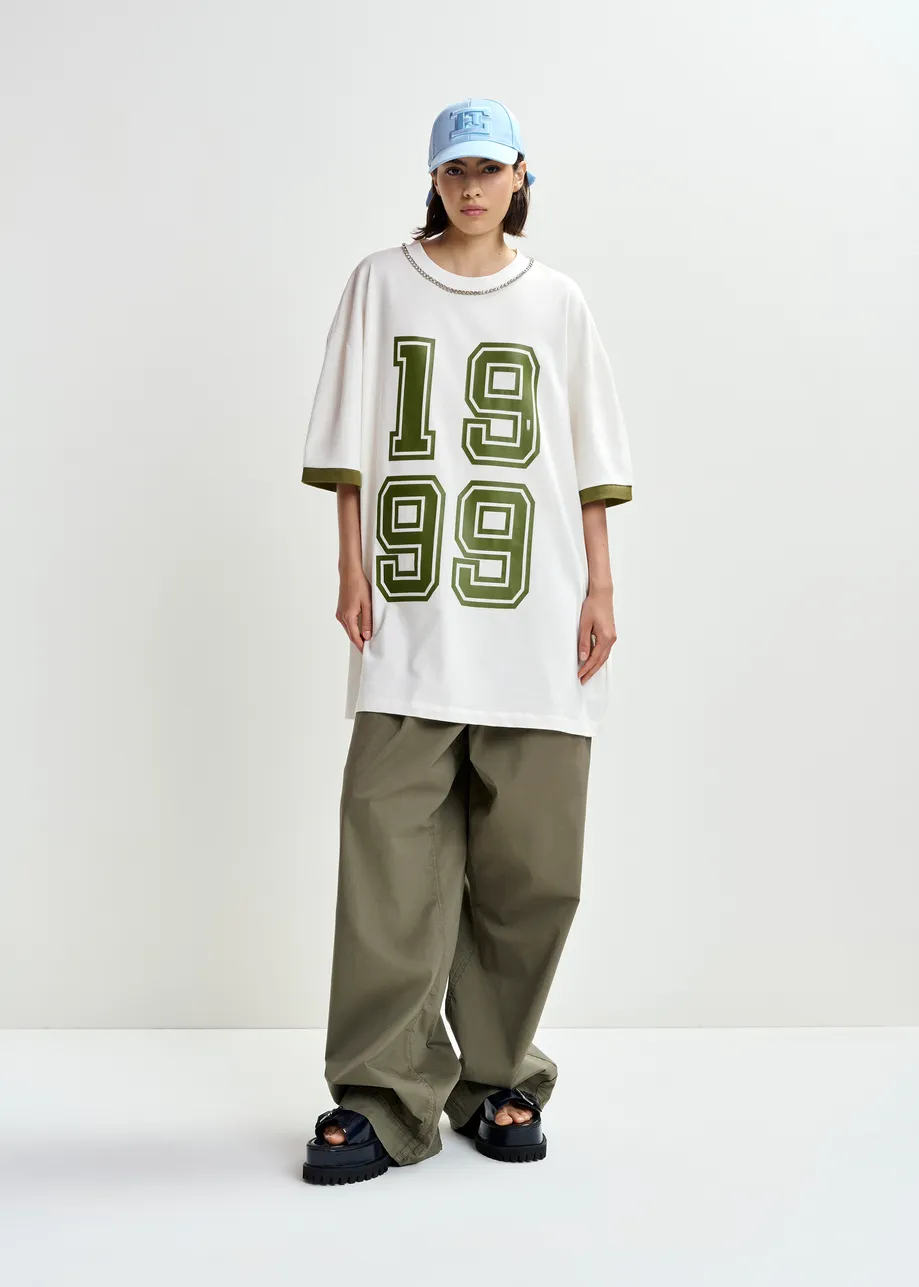 Camiseta de algodón oversize con escote adornado con strass y estampado numérico, blanco roto