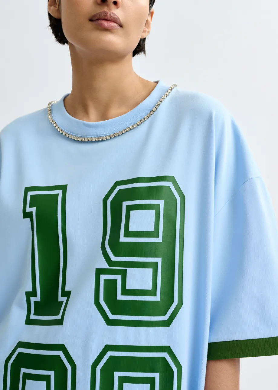 Camiseta de algodón oversize con escote adornado con strass y estampado numérico, azul
