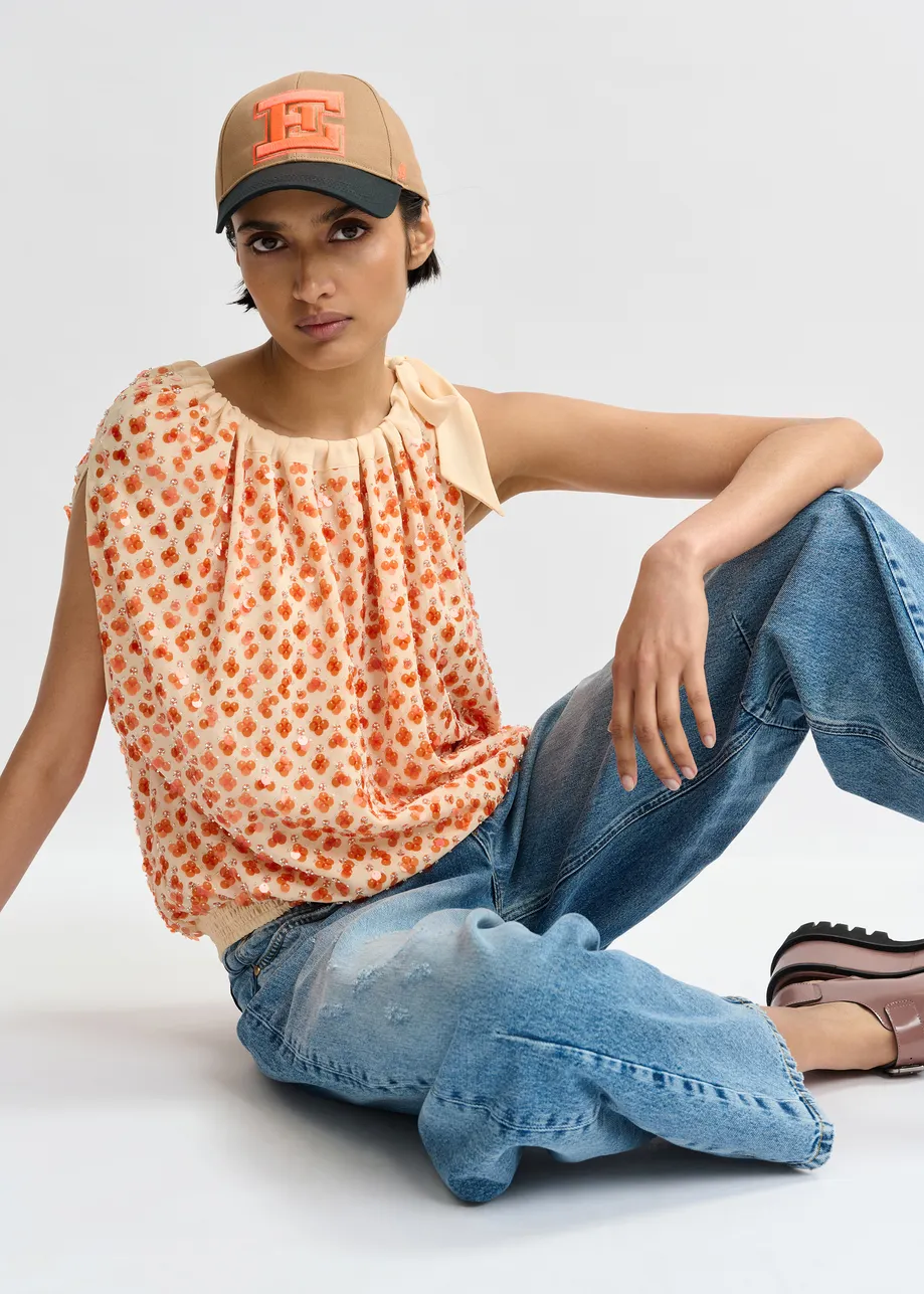 Oranje asymmetrische top met pailletten en strik