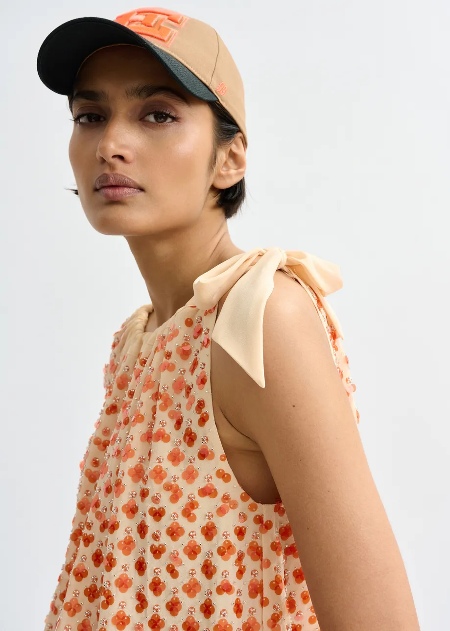 Oranje asymmetrische top met pailletten en strik