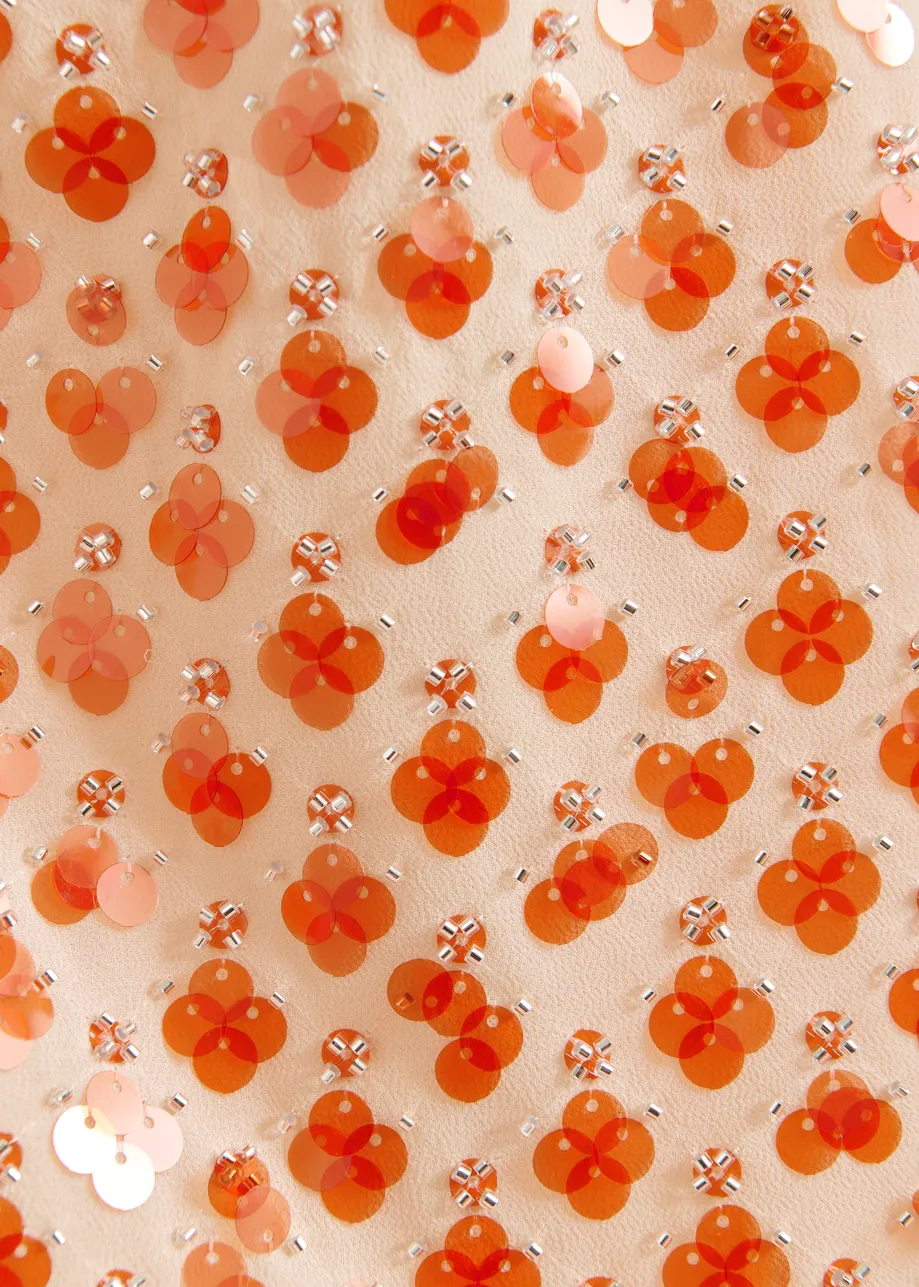 Oranje asymmetrische top met pailletten en strik