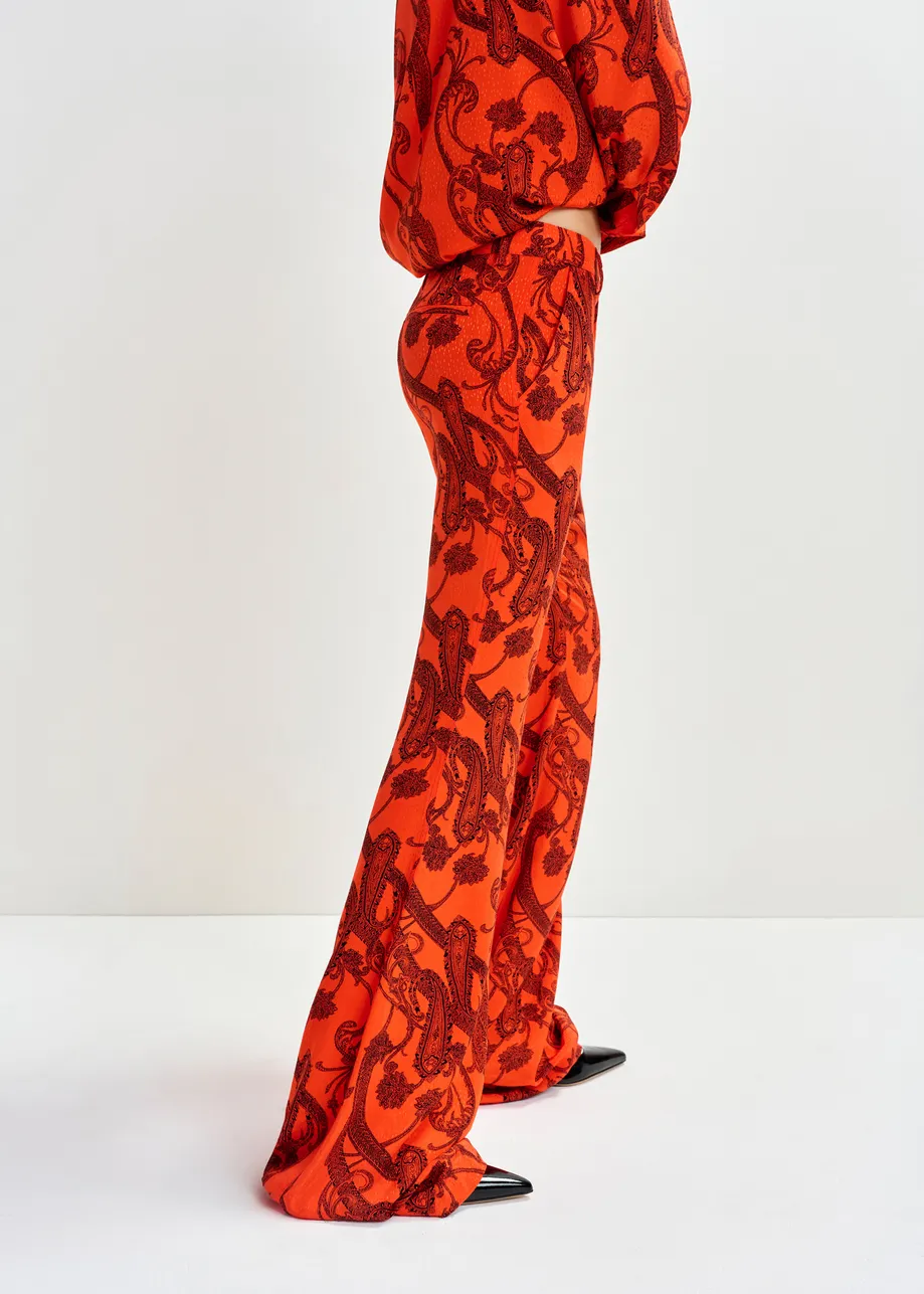 Oranje en zwarte broek met uitlopende pijp en paisleyprint