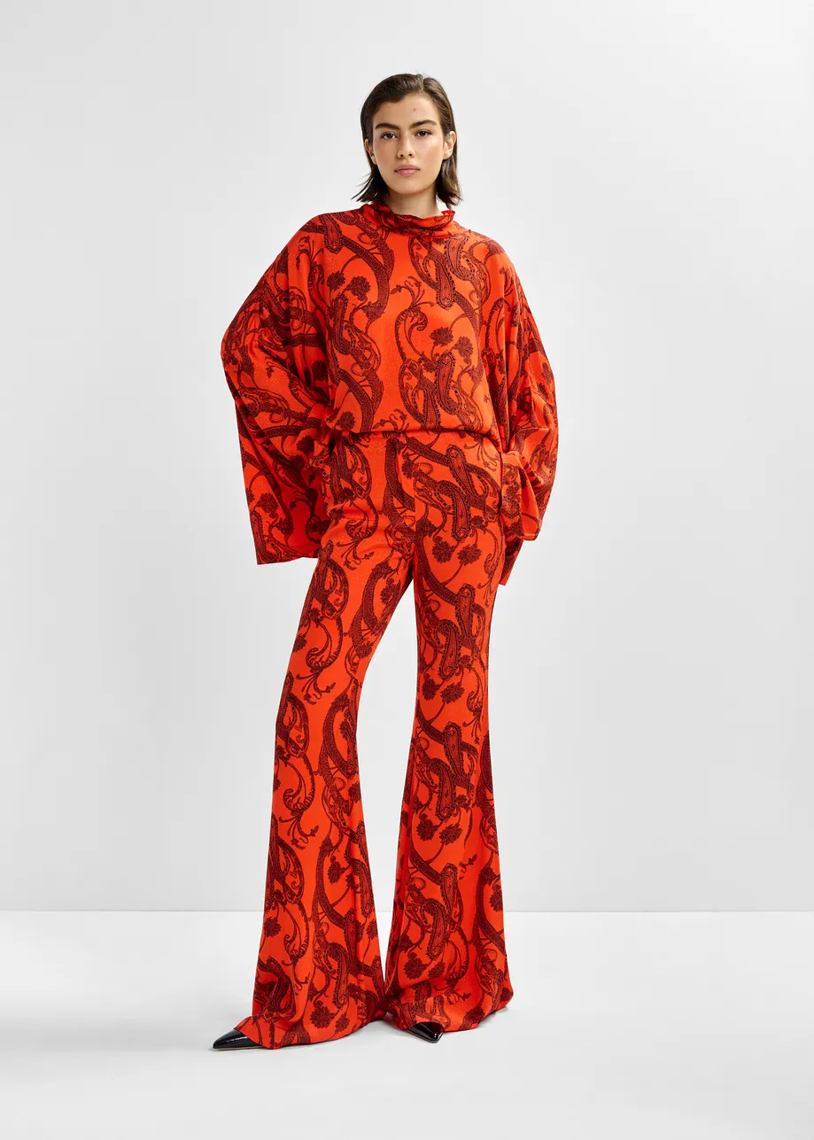 Oranje en zwarte broek met uitlopende pijp en paisleyprint