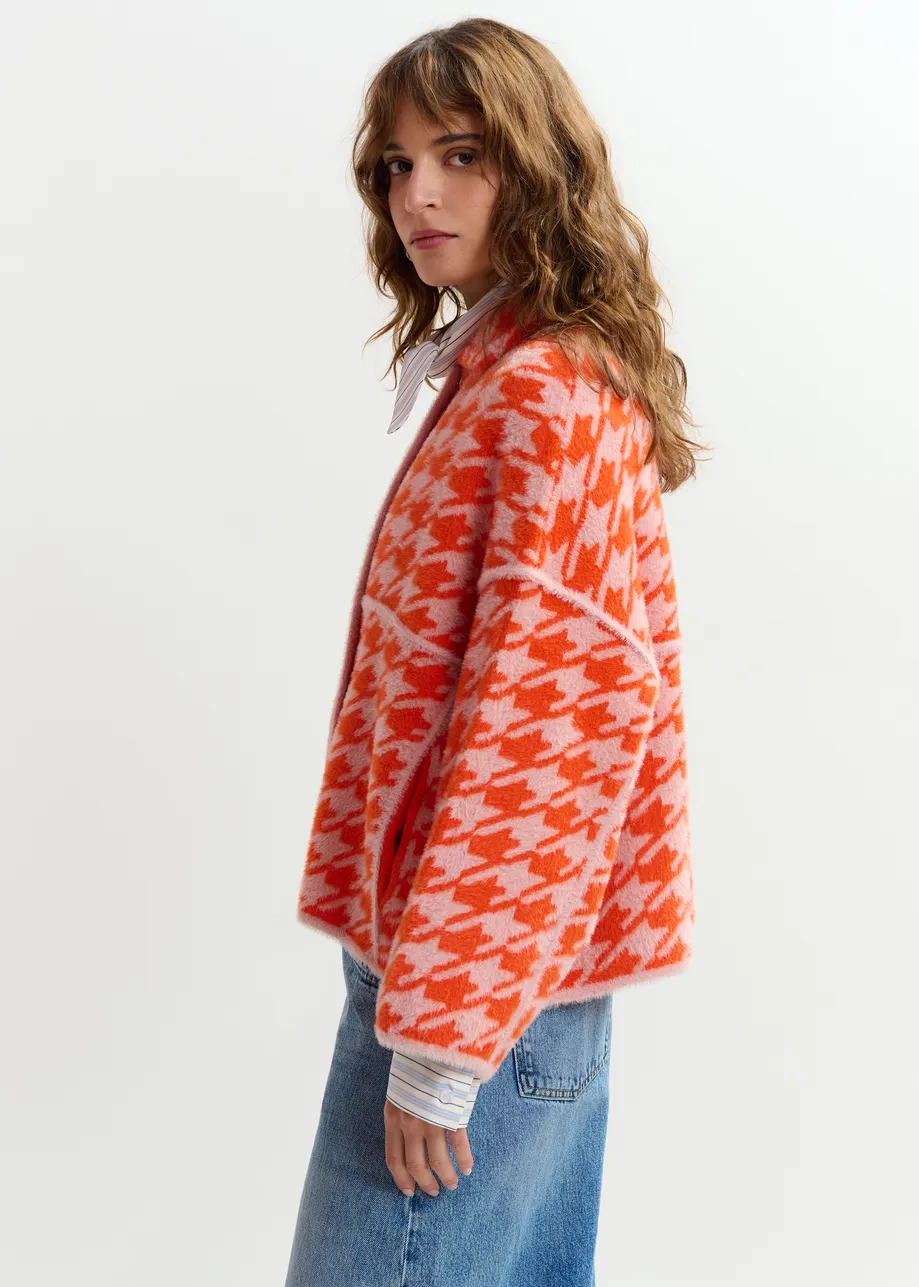 Gebreid vest met oranje en poederroze pied-de-poulepatroon