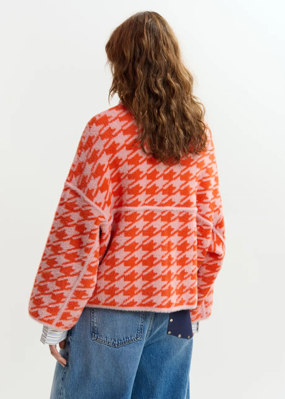 Gebreid vest met oranje en poederroze pied-de-poulepatroon