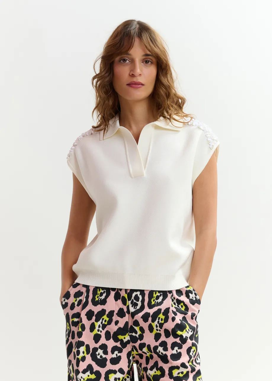 Polo blanco roto sin mangas con hombros adornados