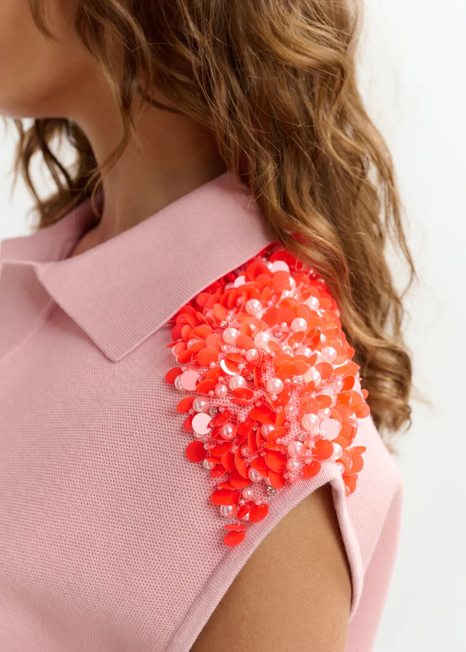 Polo rosa claro sin mangas con hombros adornados en naranja