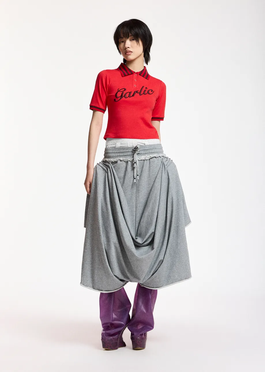 Hellgraue, drapierte Jerseyhose mit Unterrock aus Spitze in Creme