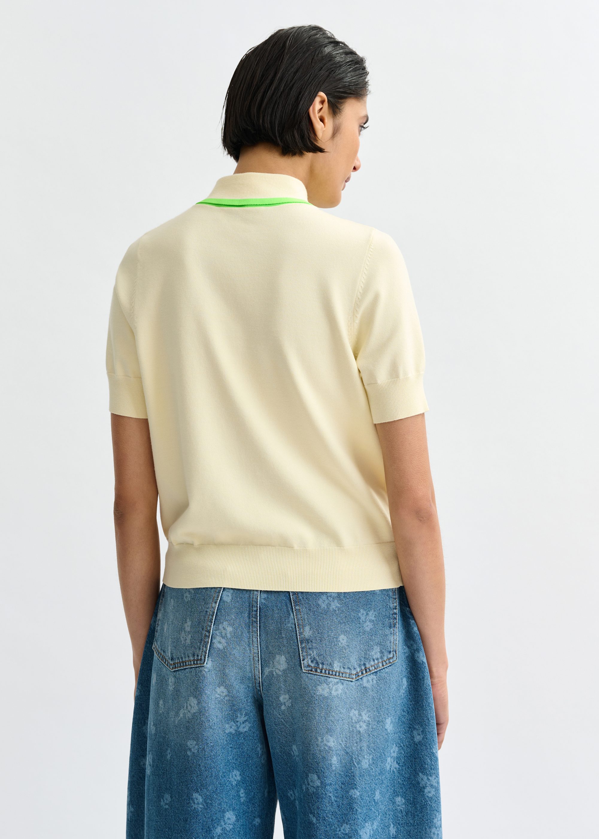Off-white fine-knit polo with light green scarf-like contrast