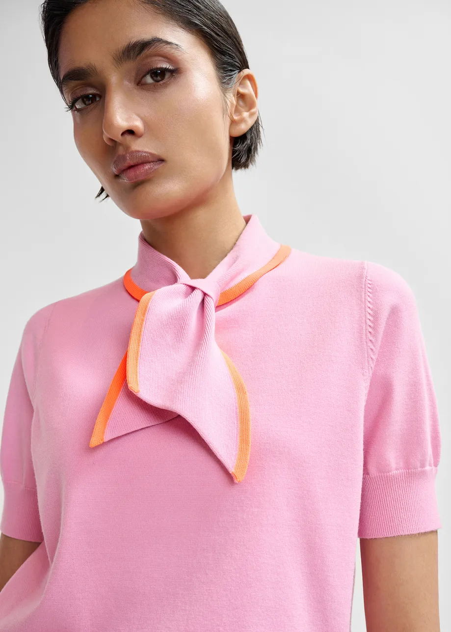 Pink fine-knit polo with orange scarf-like contrast collar