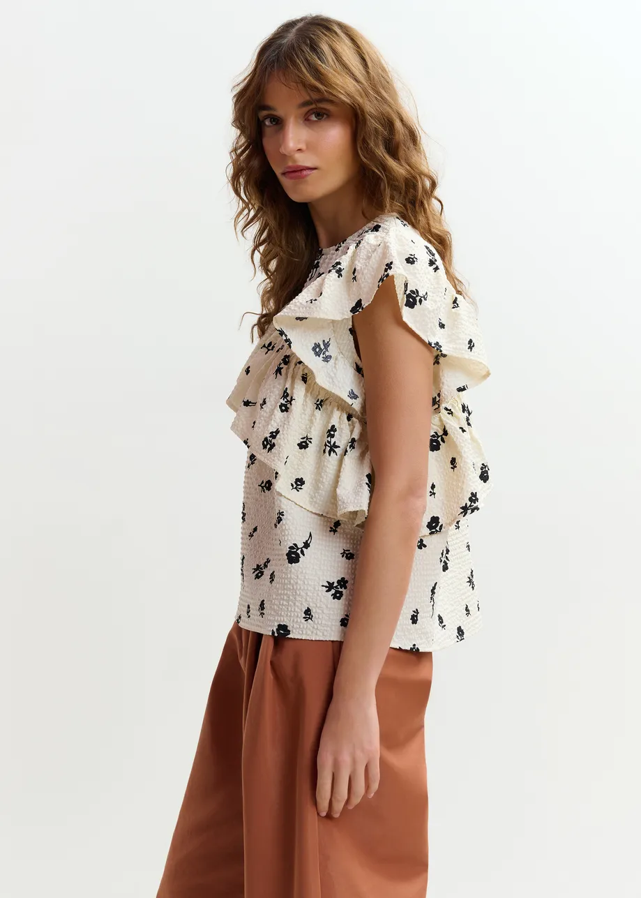 Off-white and black asymmetrical top with ruffle details