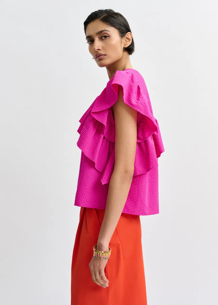 Pink asymmetrical top with ruffle details