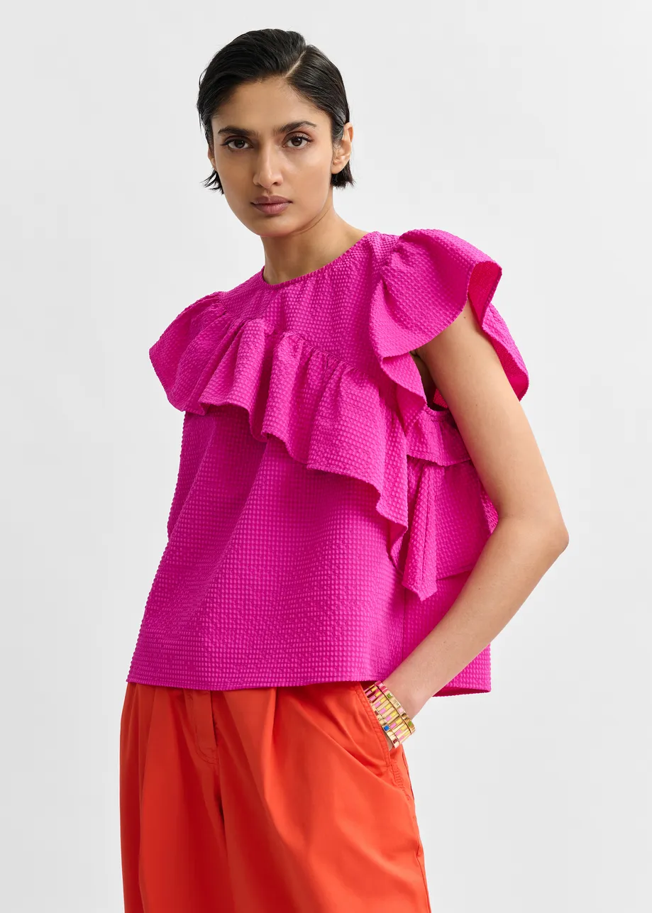 Pink asymmetrical top with ruffle details