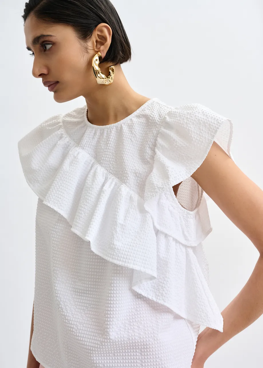 White asymmetrical top with ruffle details