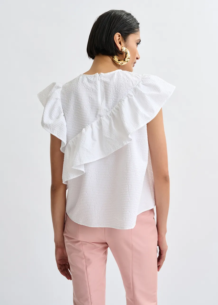 White asymmetrical top with ruffle details