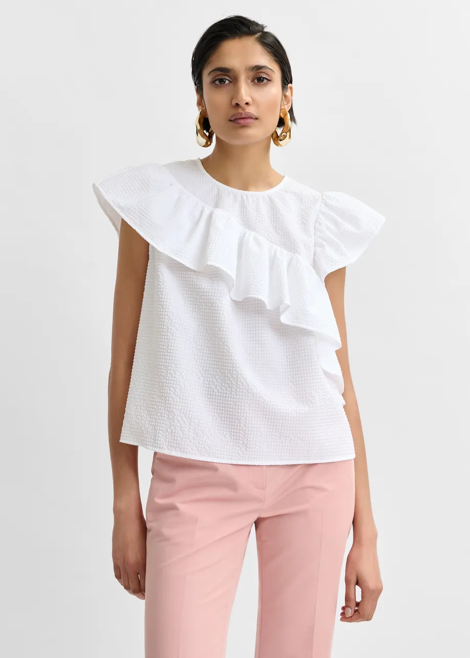 White asymmetrical top with ruffle details