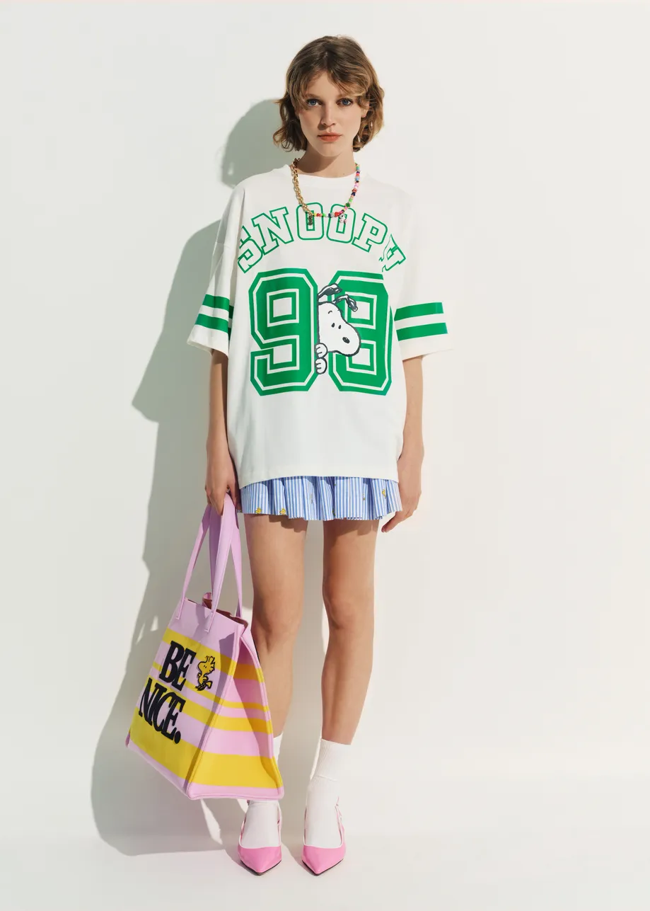 Off-white T-shirt with Peanuts™ Snoopy print and green text