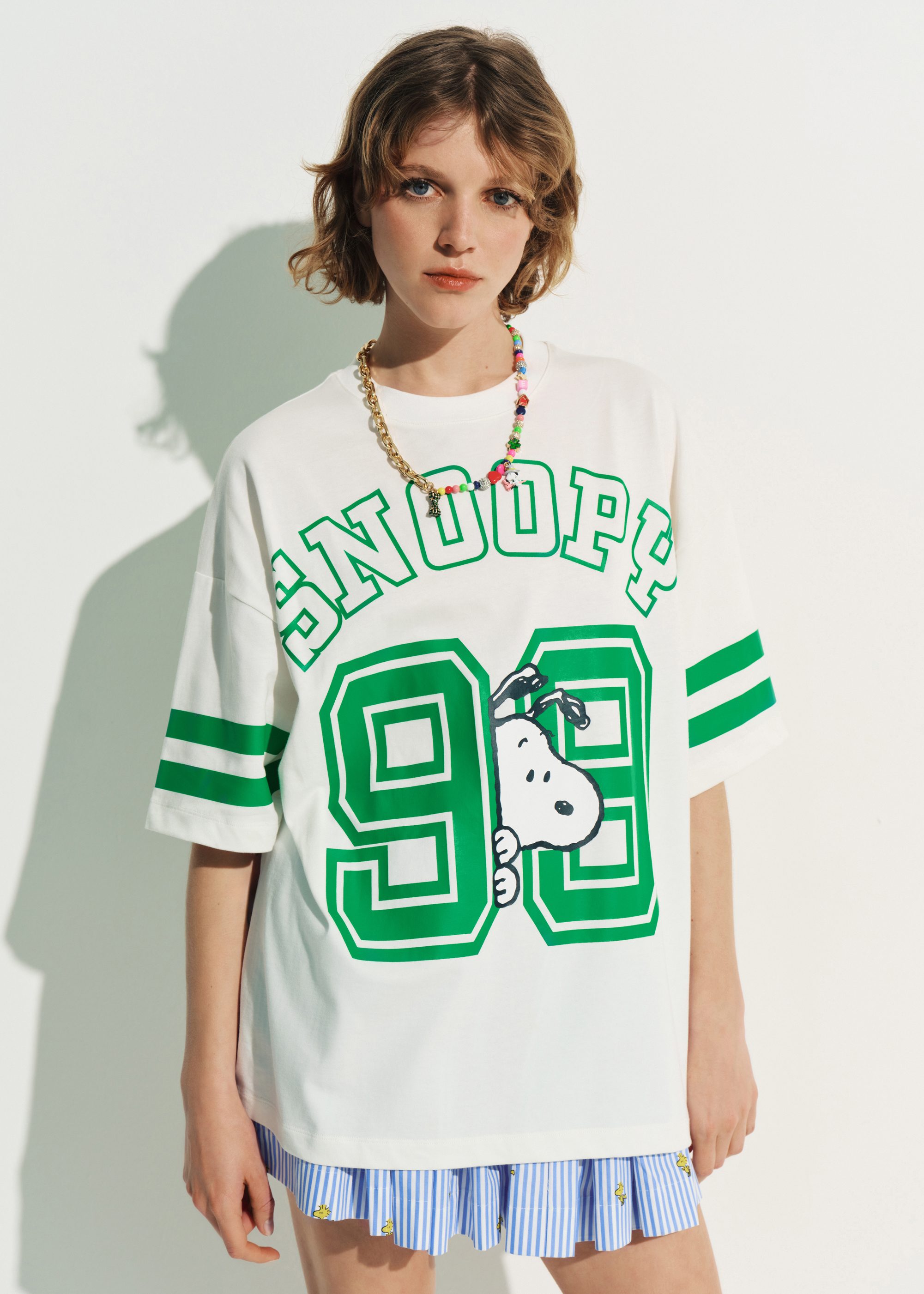 Off-white T-shirt with Peanuts™ Snoopy print and green text