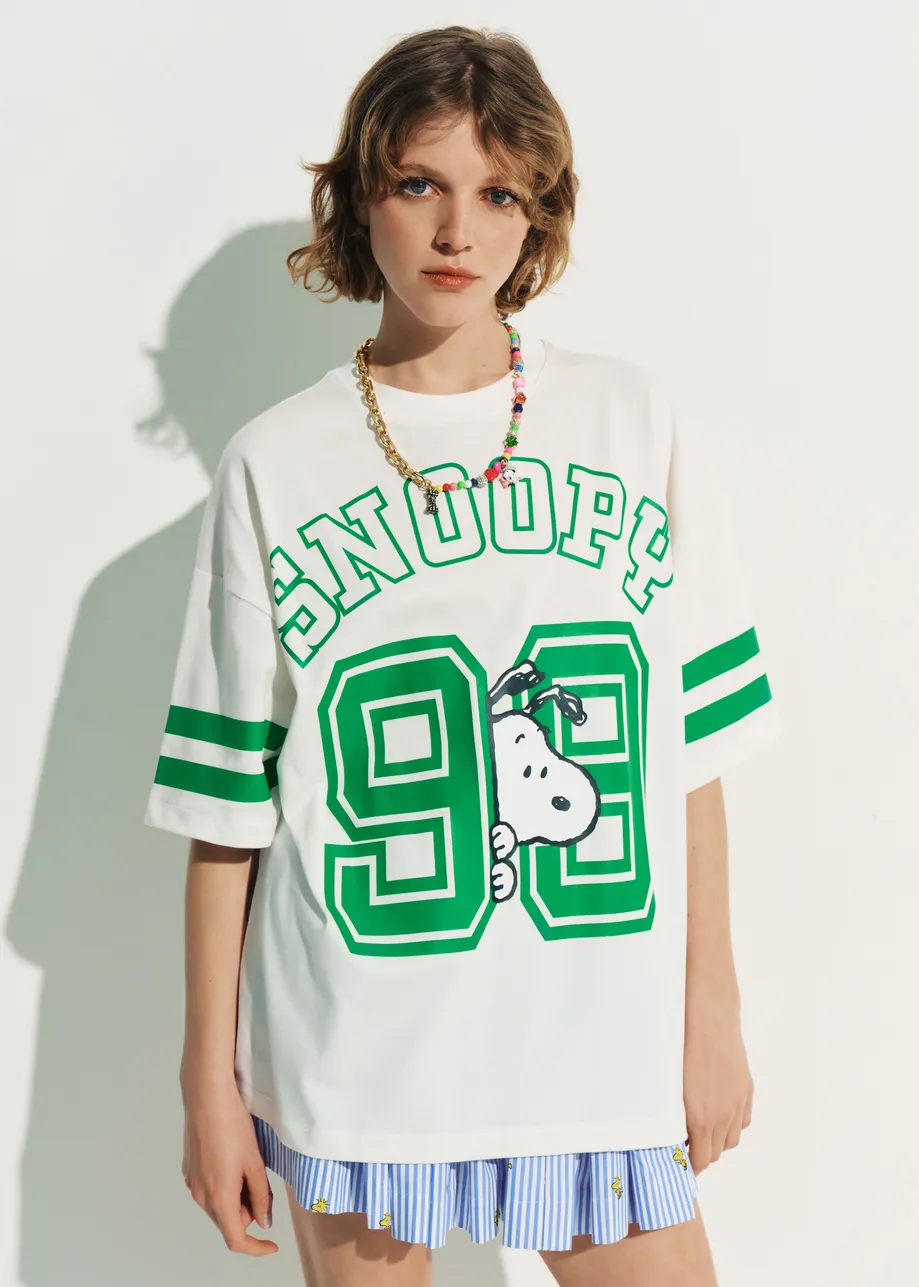 Off-white T-shirt with Peanuts™ Snoopy print and green text