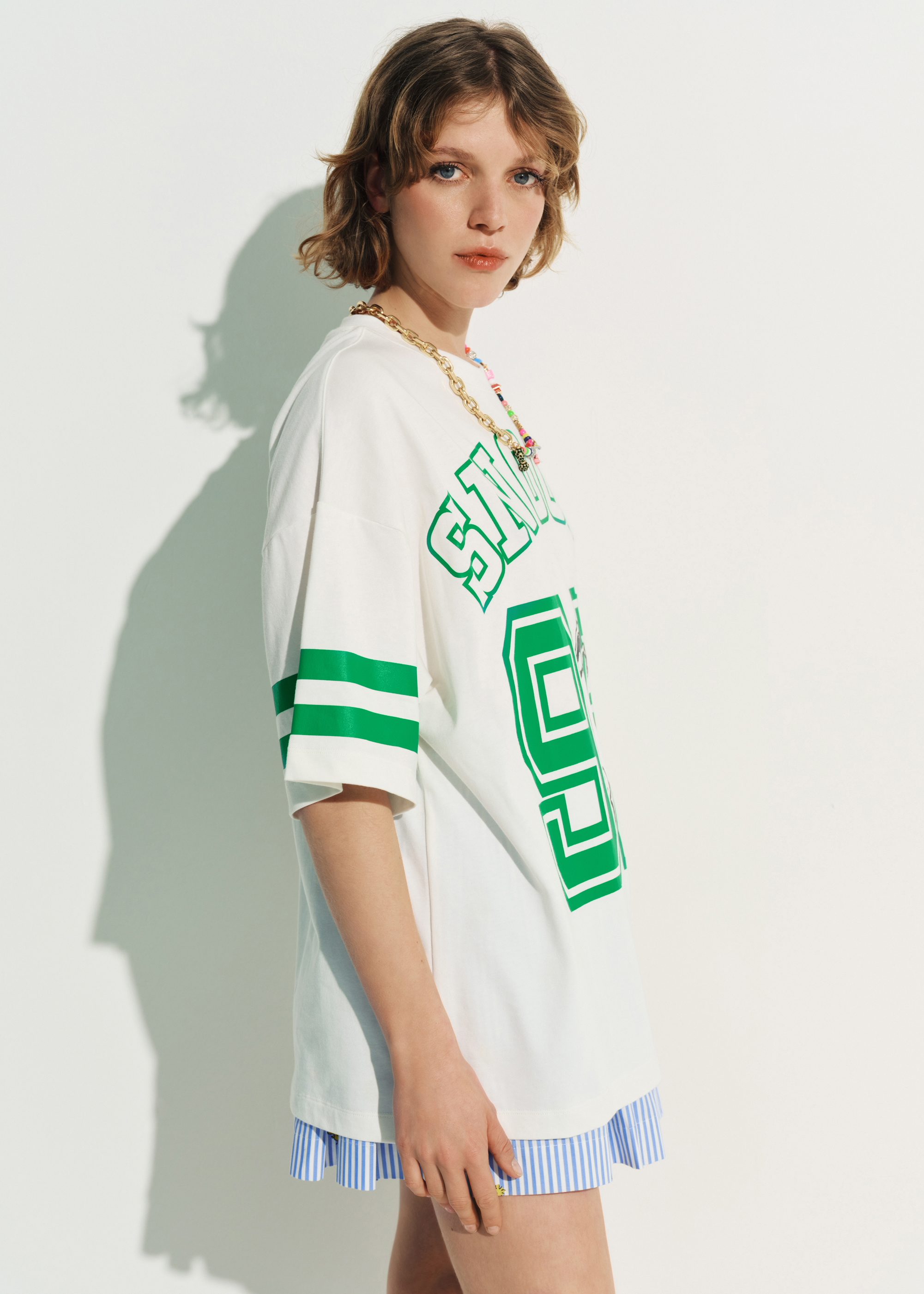 Off-white T-shirt with Peanuts™ Snoopy print and green text