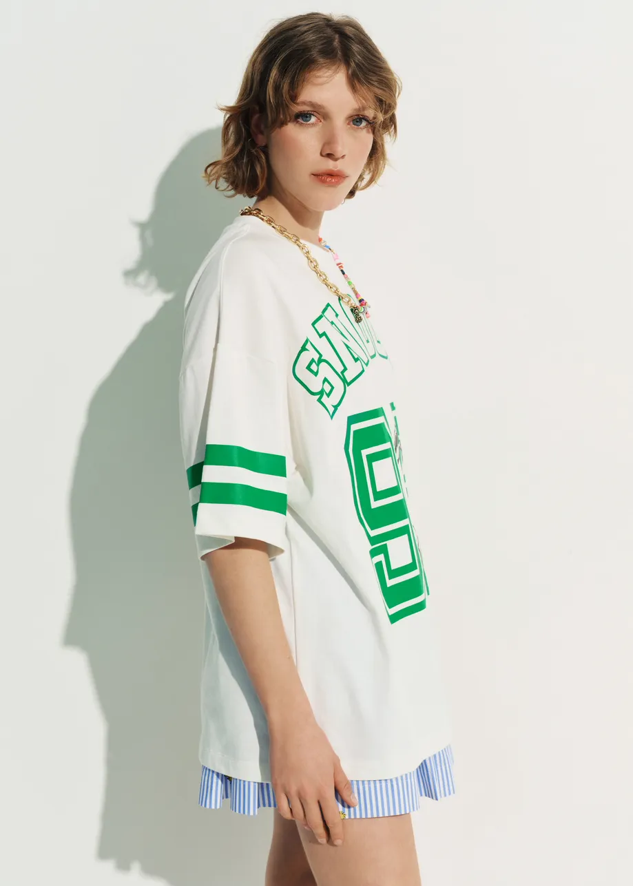 Off-white T-shirt with Peanuts™ Snoopy print and green text