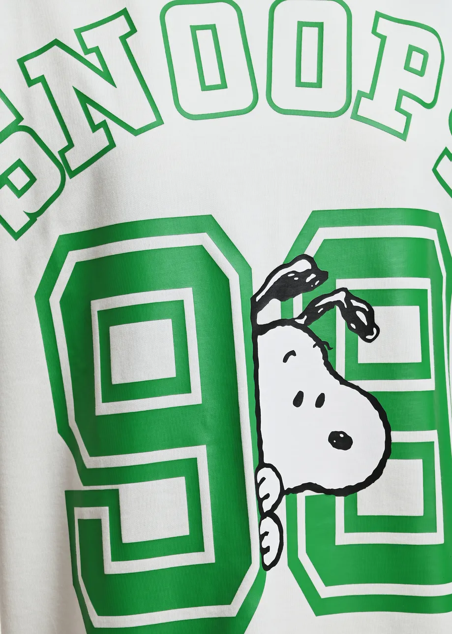 Off-white T-shirt with Peanuts™ Snoopy print and green text