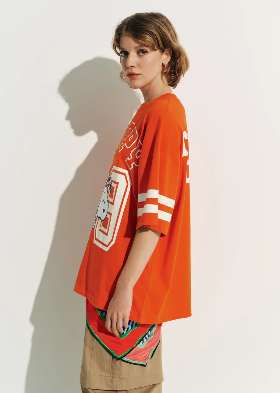 Orange T-shirt with Peanuts™ Snoopy print and white text