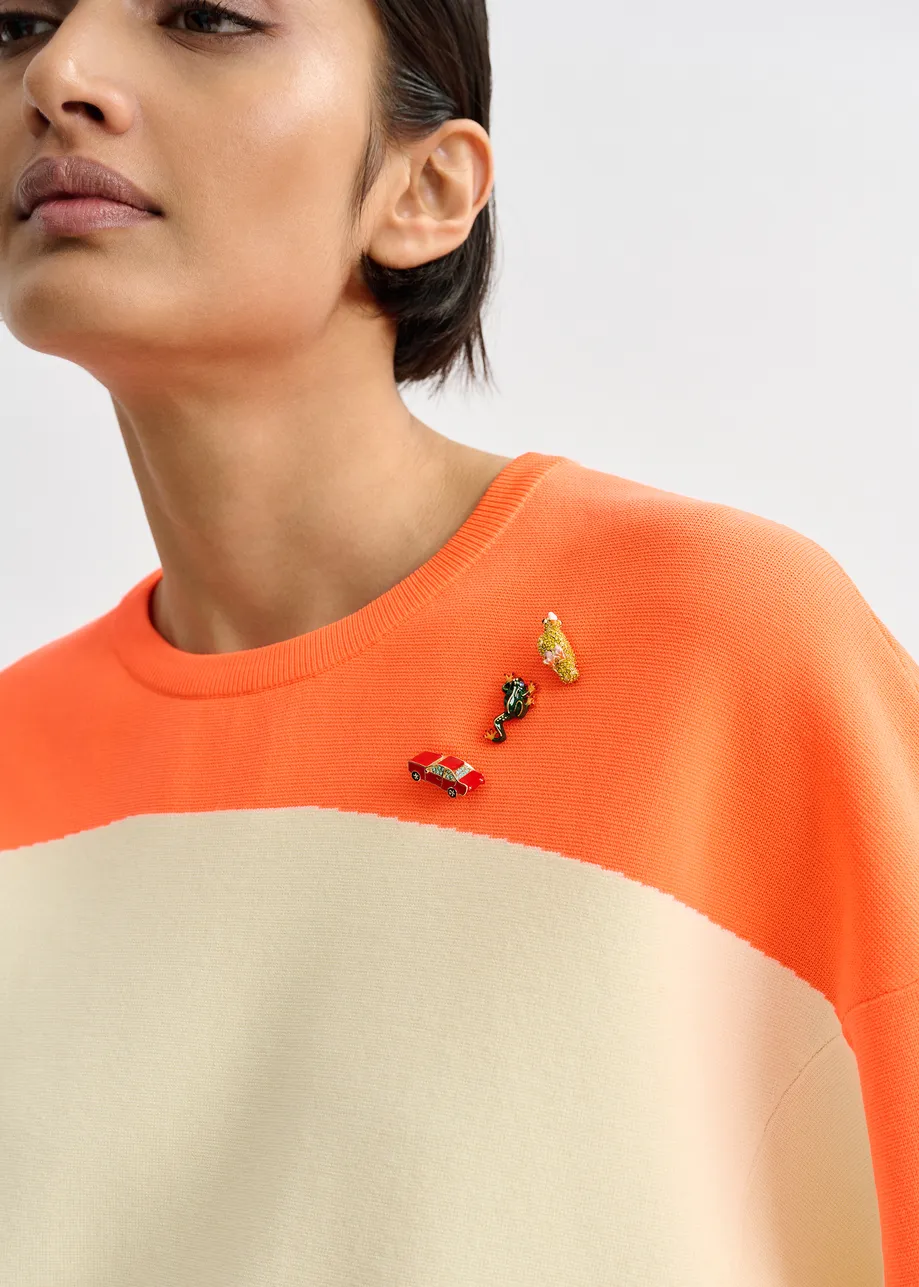 Gebroken witte en oranje gebreide trui