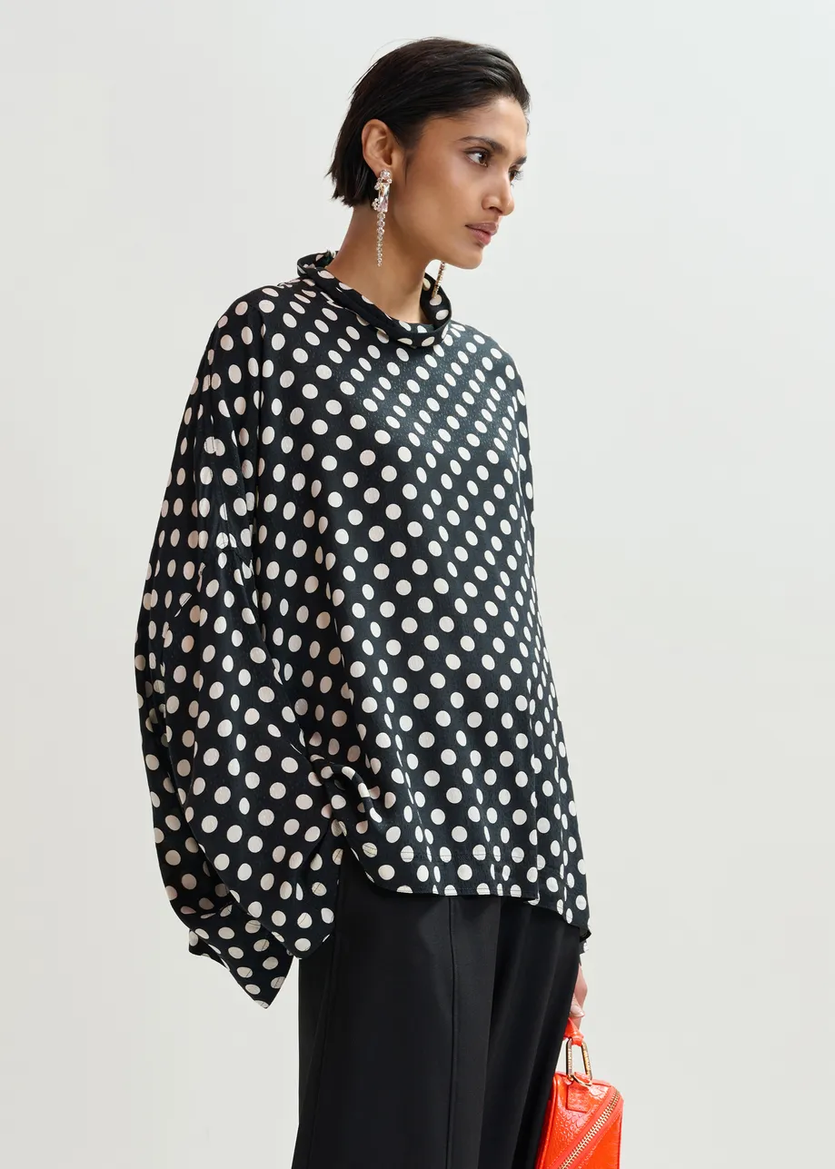 Zwart-witte oversized top met hoge halslijn en stippenprint