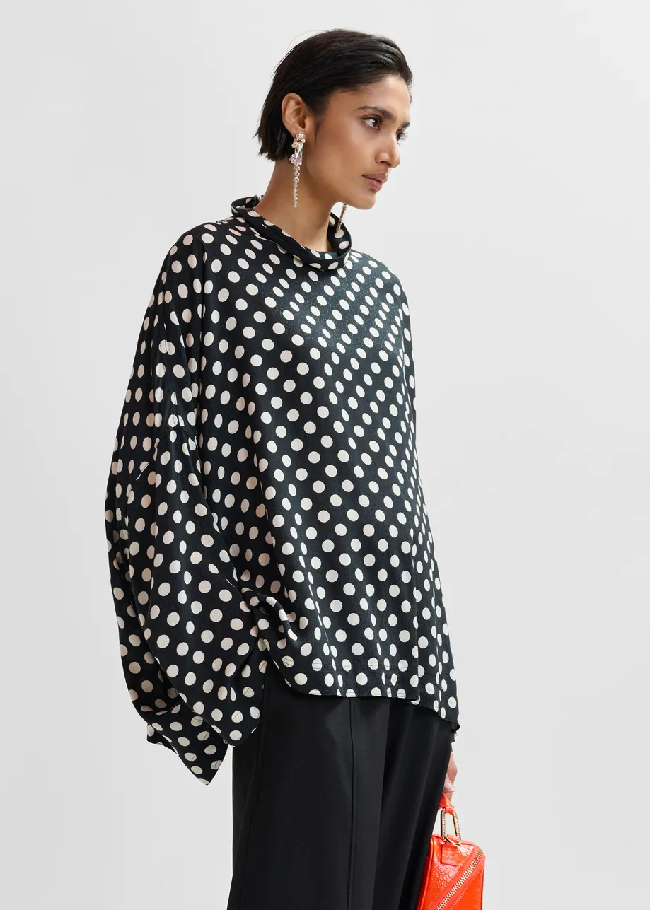 Zwart-witte oversized top met hoge halslijn en stippenprint