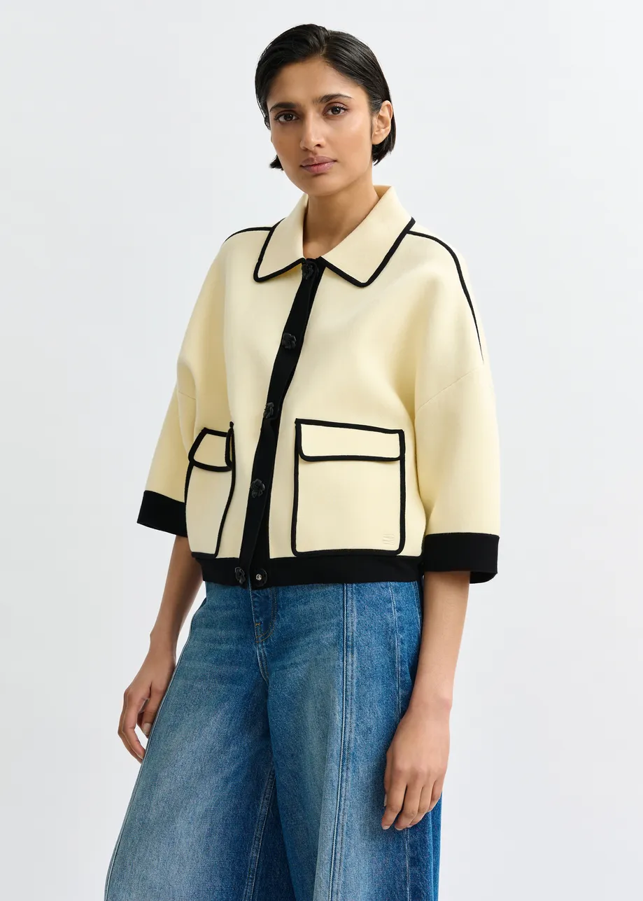 Gebroken witte cardigan met bloemetjesknopen en zwarte contrastboord