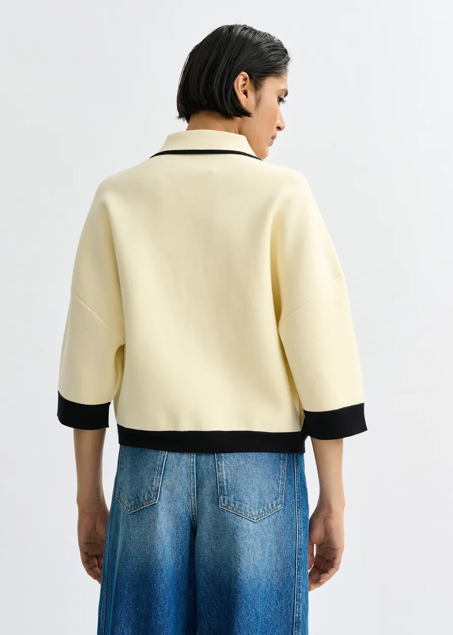 Gebroken witte cardigan met bloemetjesknopen en zwarte contrastboord