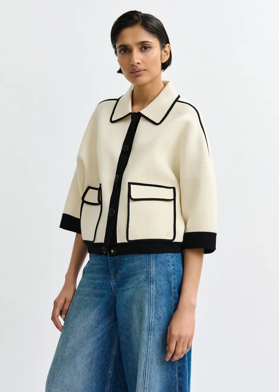 Gebroken witte cardigan met bloemetjesknopen en zwarte contrastboord