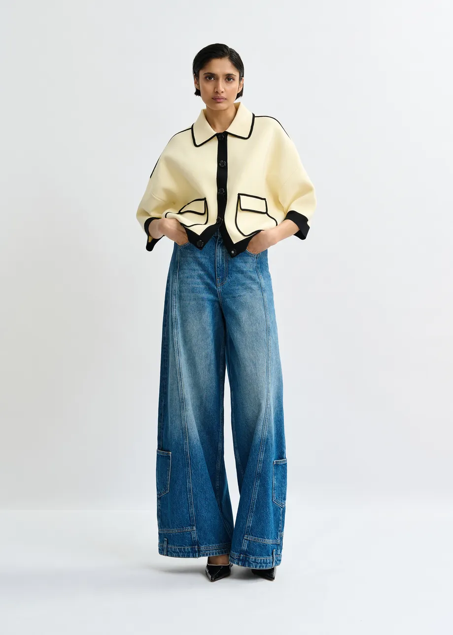 Off-white knit cardigan with flower buttons and black contrasting trims