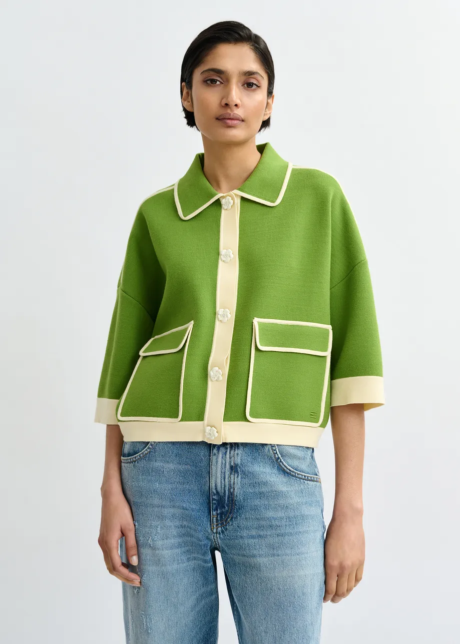 Groene cardigan met bloemetjesknopen en gebroken witte contrastboord