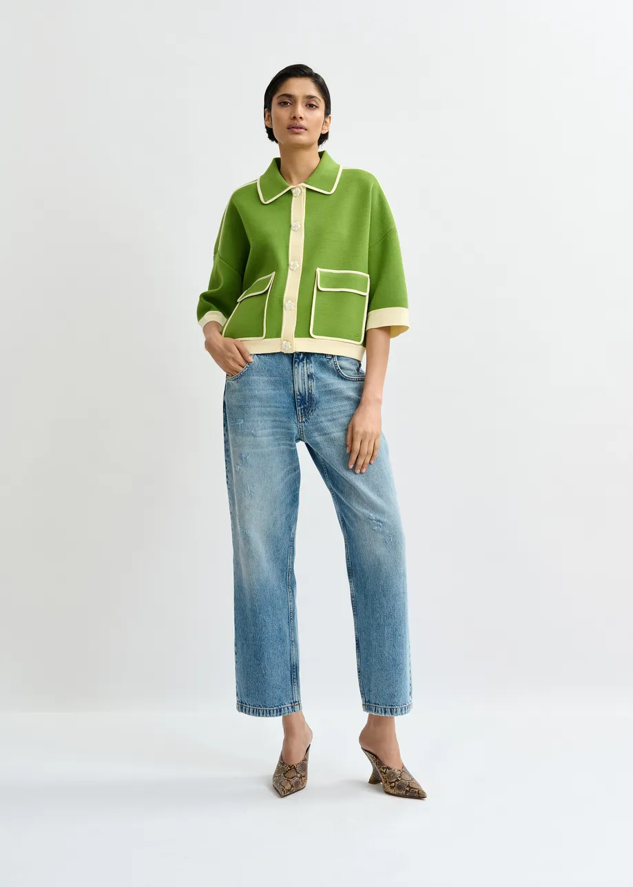 Groene cardigan met bloemetjesknopen en gebroken witte contrastboord