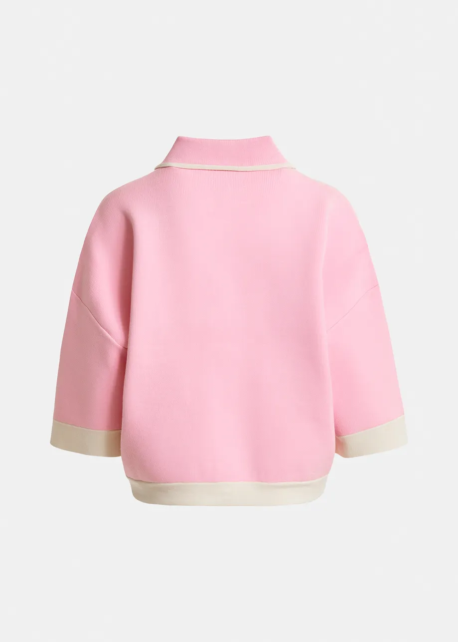 Roze cardigan met bloemetjesknopen en gebroken witte contrastboord